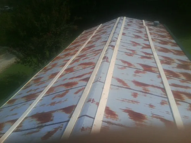 Rusted metal roof panels with new wood purlins before replacement — Storm Damage Roof Repair in Paola by Roofing Brothers