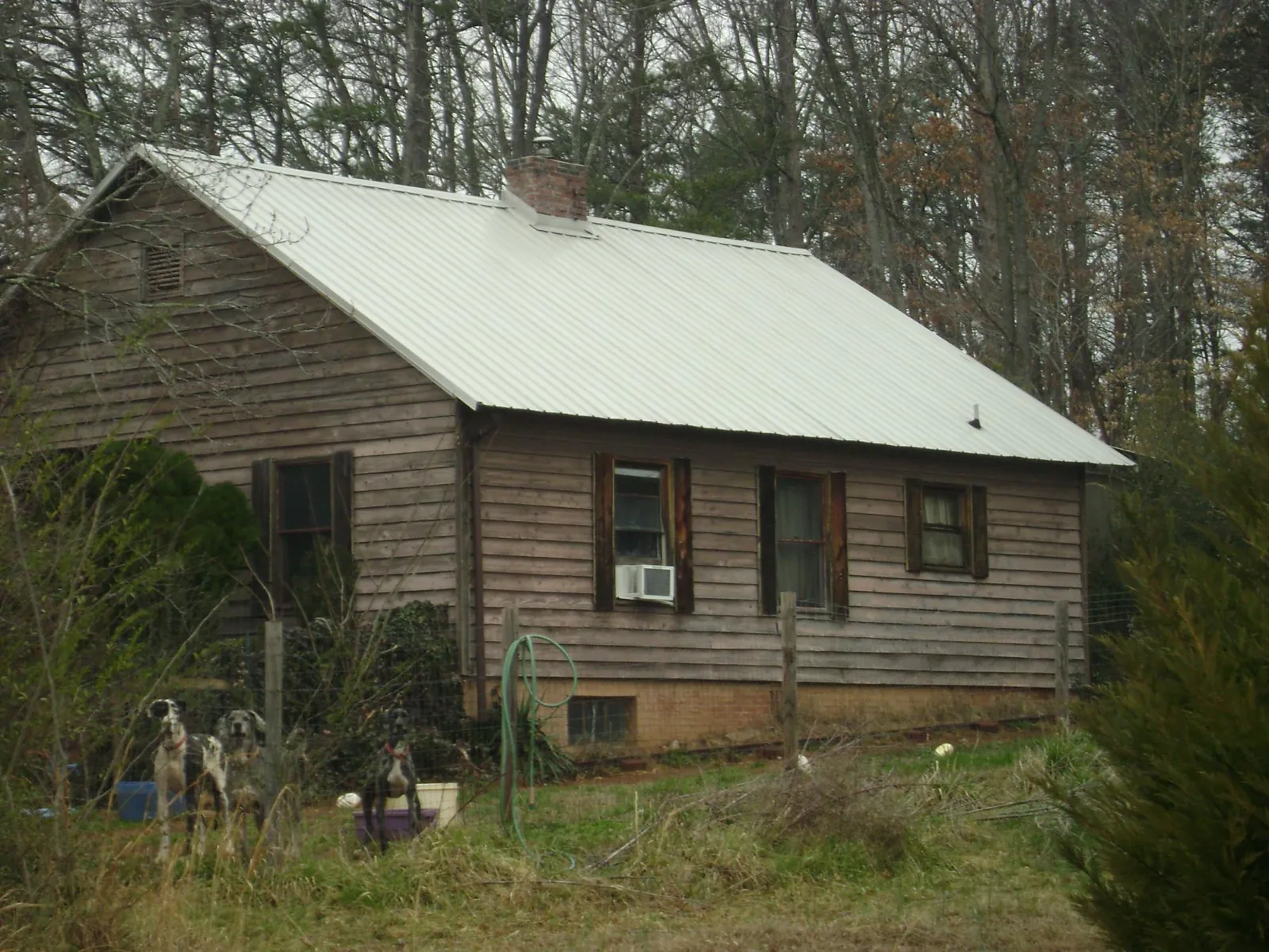 White metal roof on an old wood sided farmhouse, from a Metal Roof Installation job in Paola